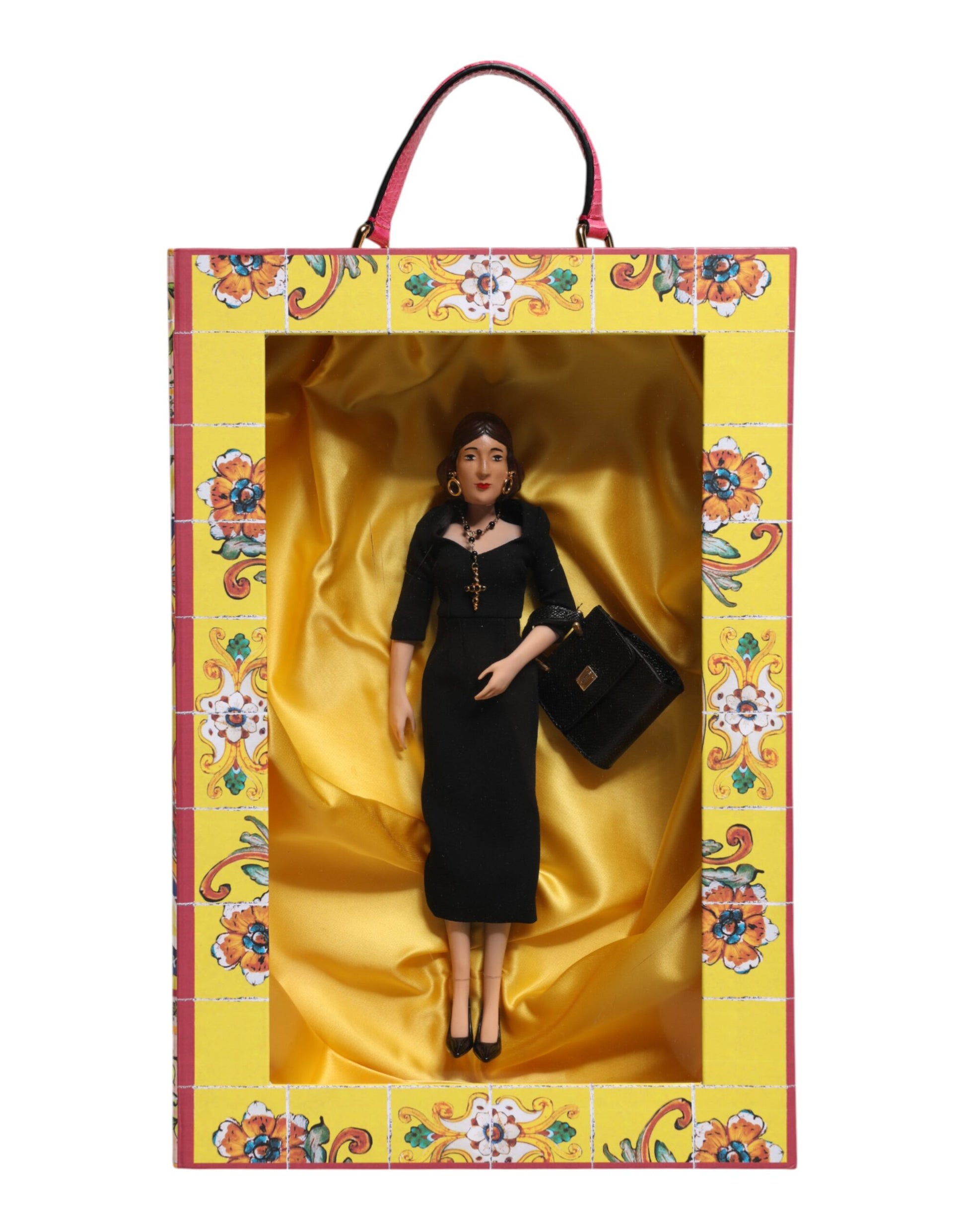 A porcelain doll wearing a black dress with gold accents