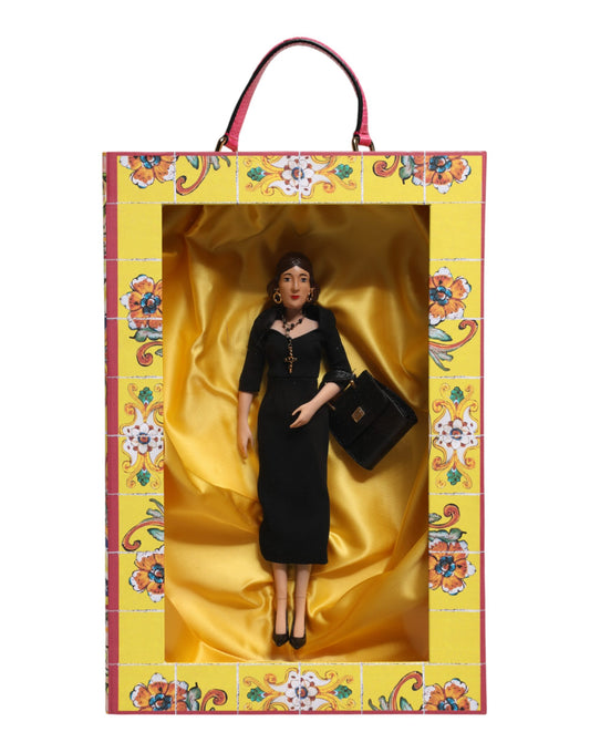 A porcelain doll wearing a black dress with gold accents