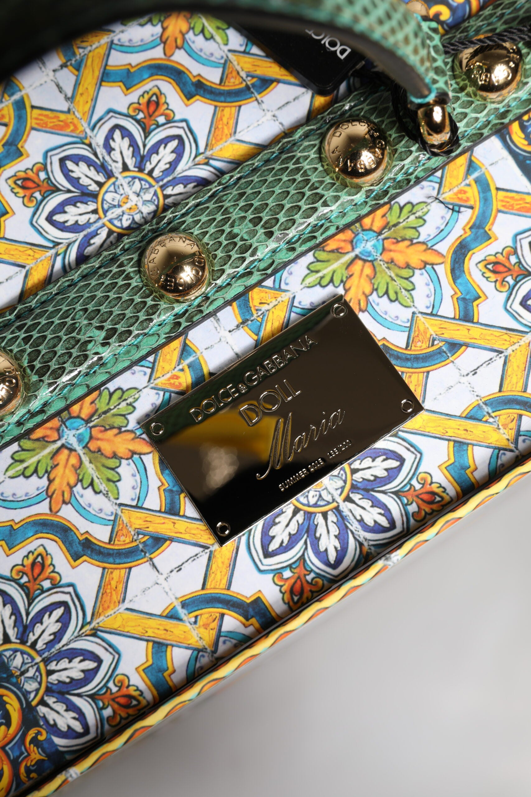 A black dress with a ceramic porcelain and leather design, featuring gold accents