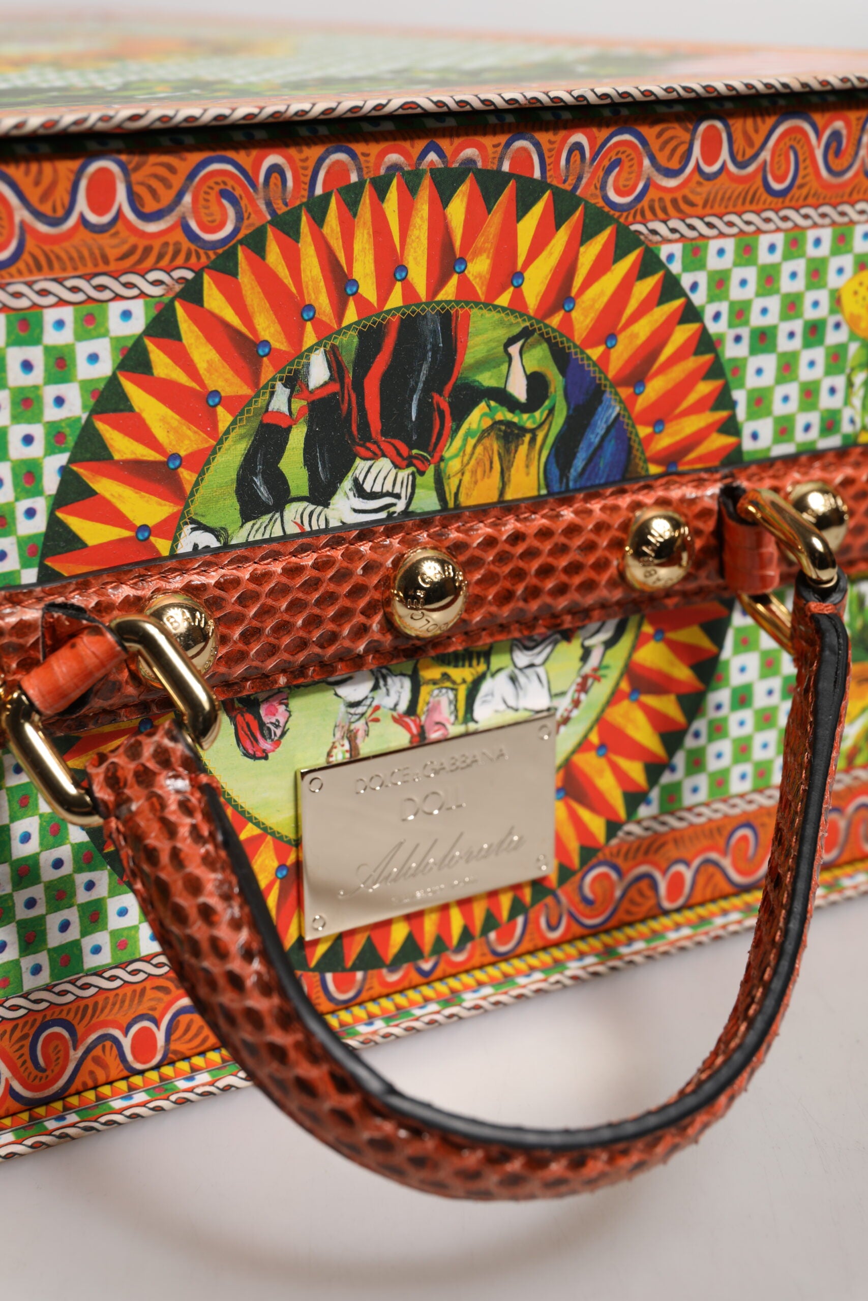 A black leather handbag with gold accents and a colorful ceramic design
