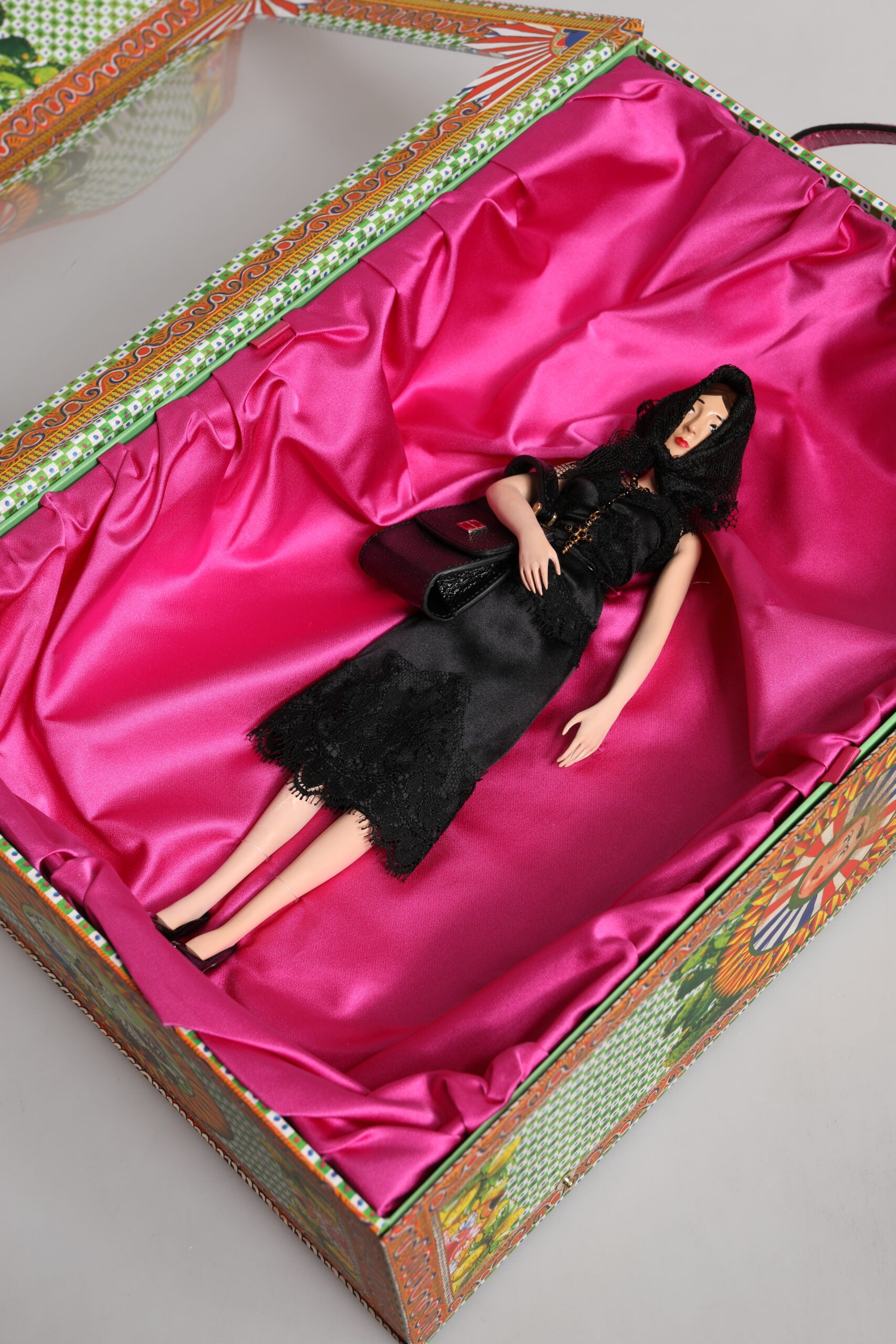 A porcelain doll wearing a black dress, part of the Dolce & Gabbana collection
