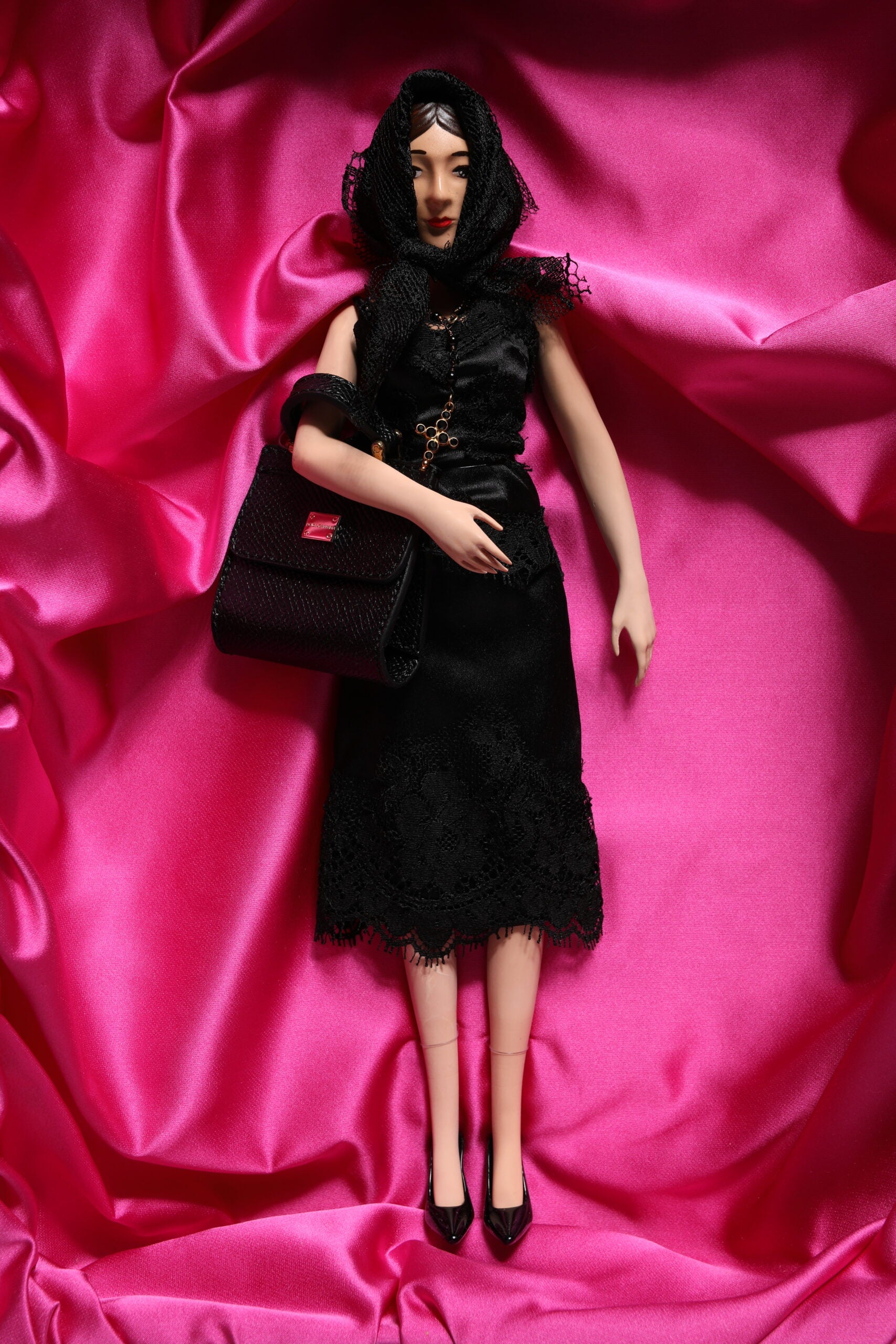 A porcelain doll wearing a black dress with lace details