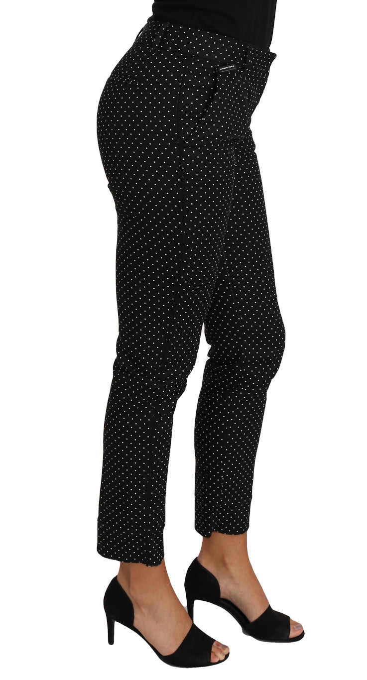 Black high heel shoes worn by a woman in polka dot pants