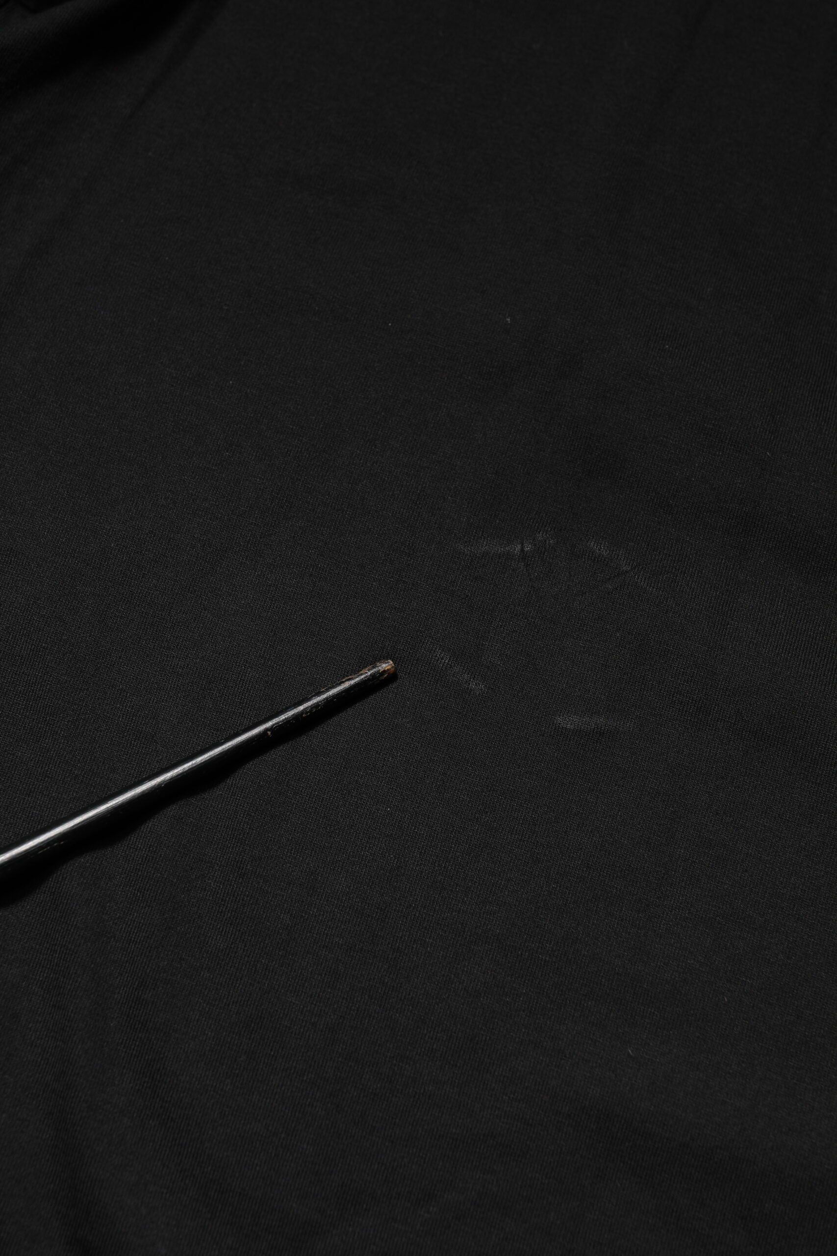 Black fabric with a small needle in it