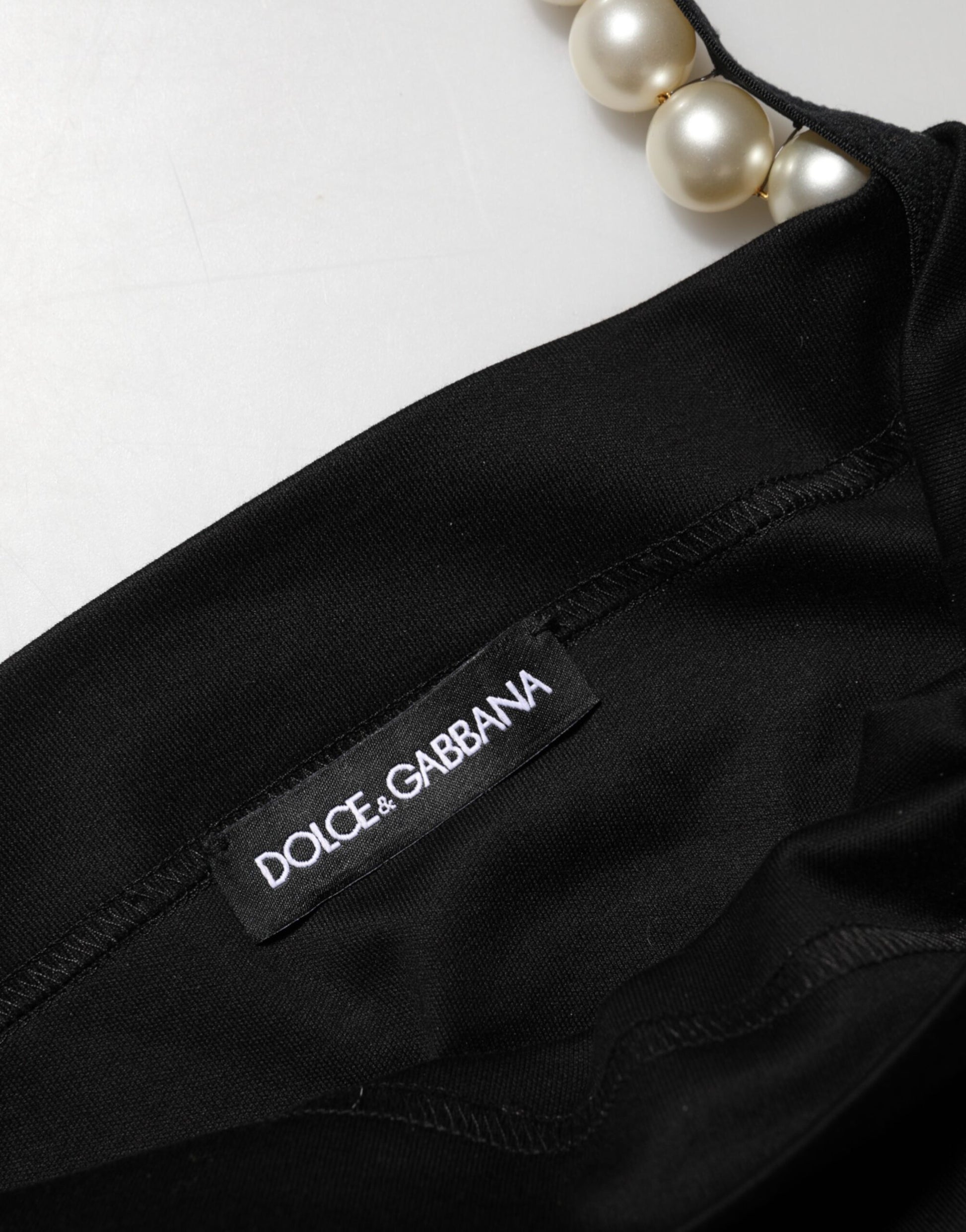 A black faux pearl cotton sheath mini dress with a label that reads "Dolce & Gabbana"