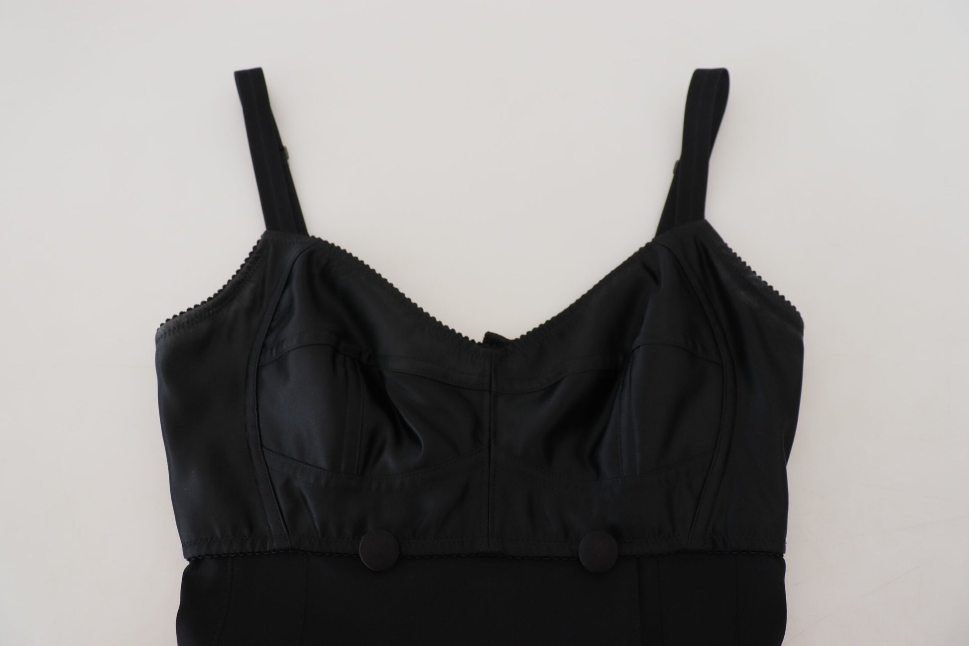 A black dress with buttons on the front, part of a sheath style mini dress