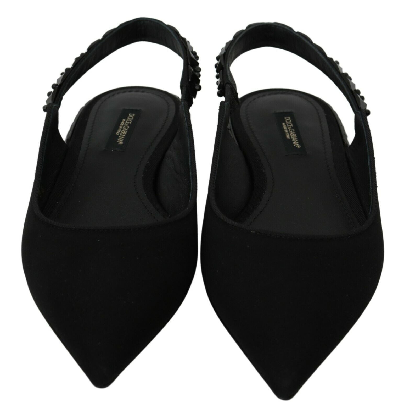 Pair of black women's shoes with pointed toe and strap over foot