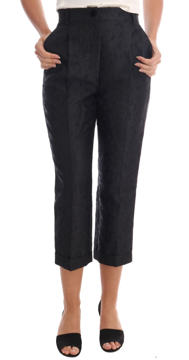 Pair of black trousers with rolled up legs