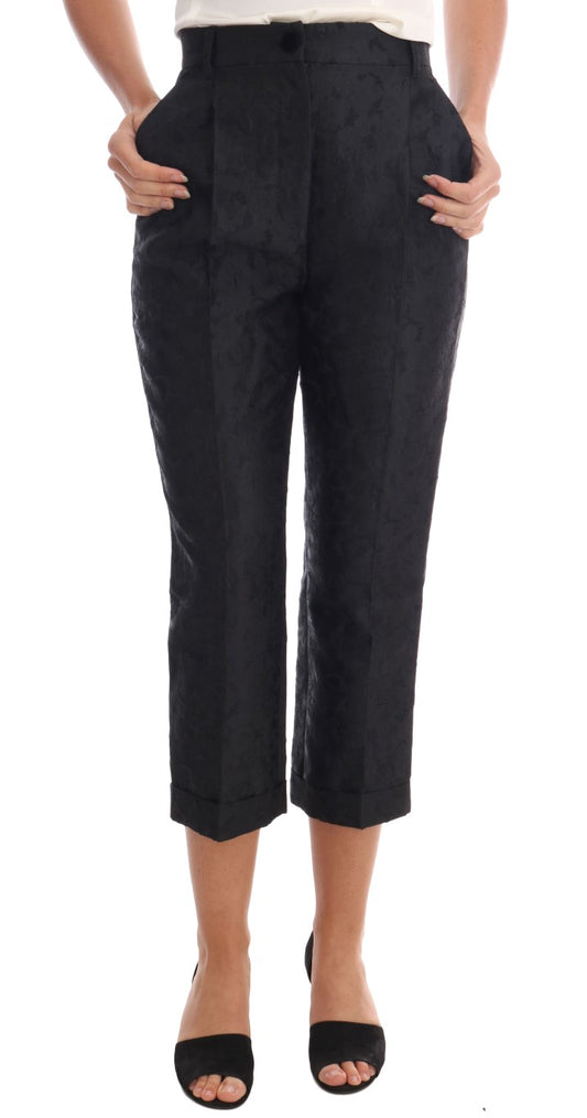Pair of black trousers with rolled up legs