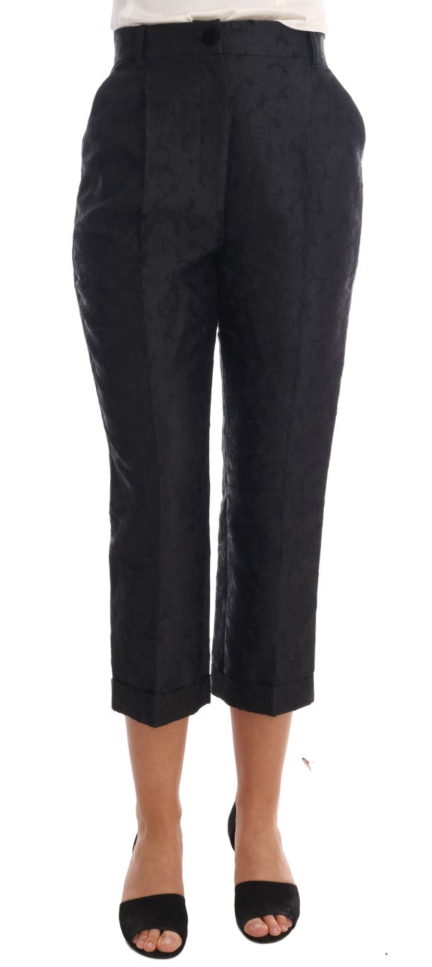 Pair of black trousers with rolled up legs