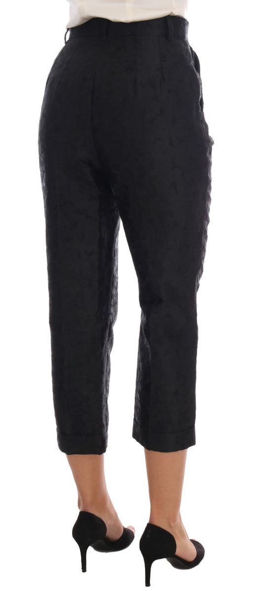 Pair of black trousers with rolled up legs