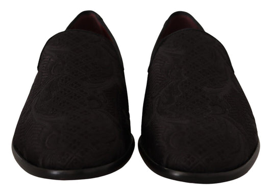 Pair of black slippers with embroidered design on soles