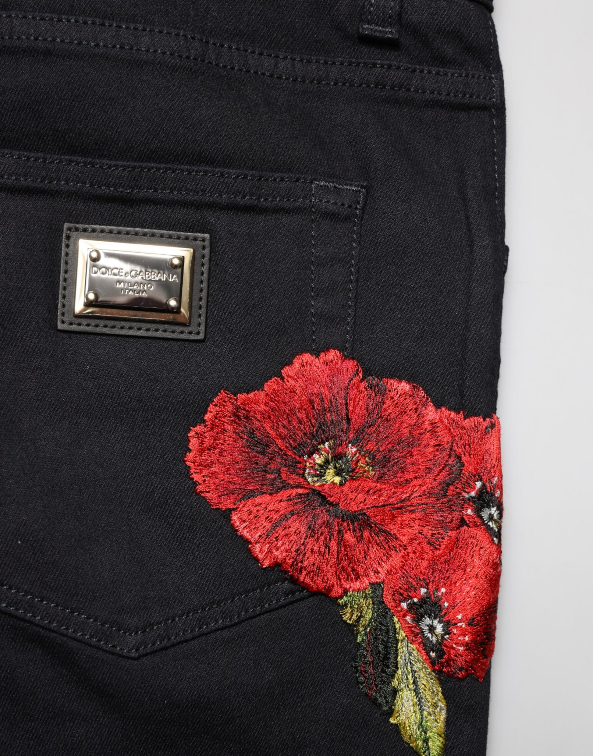 Black jeans with red flower embroidery on right leg