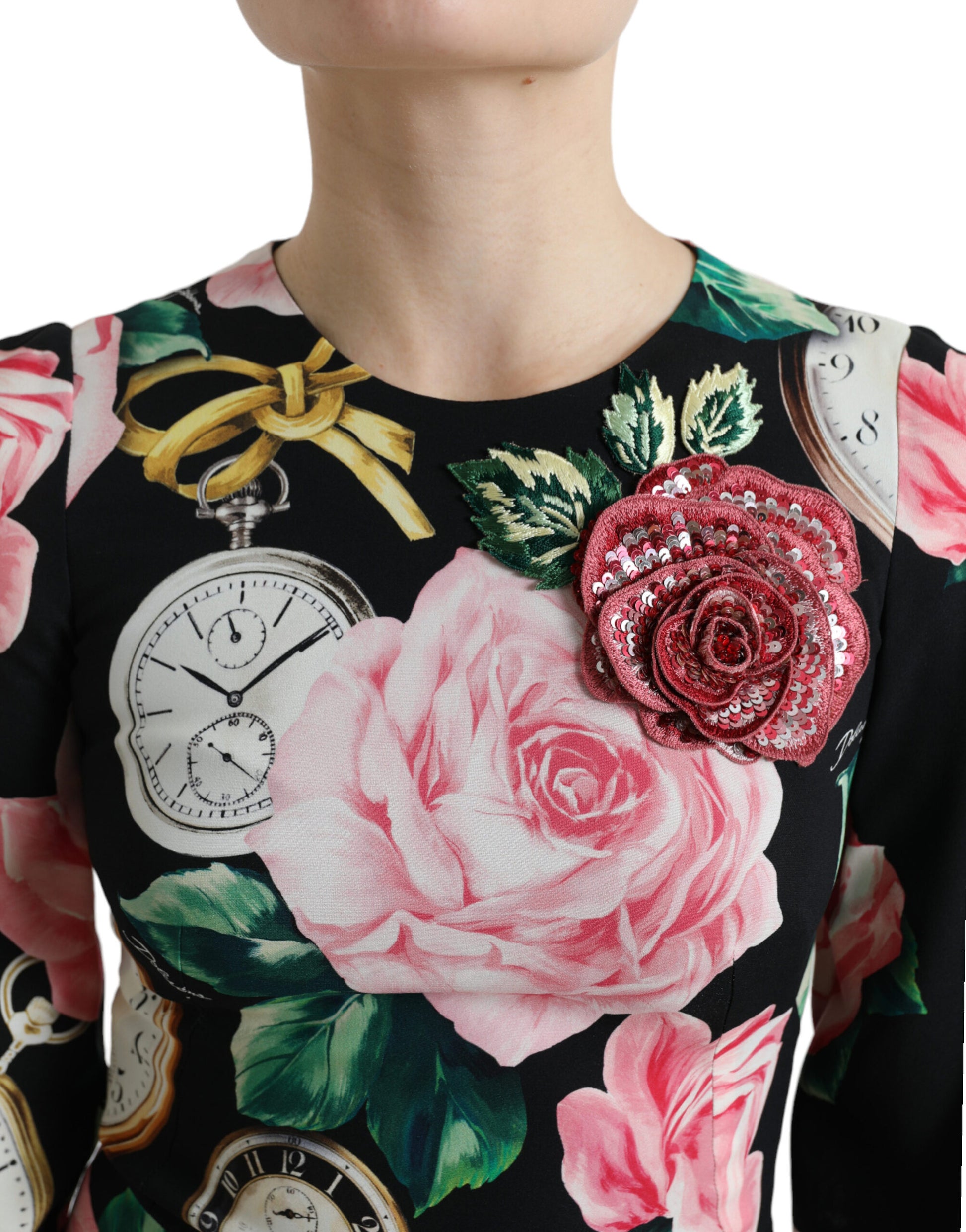 A black dress with floral and lace embellishments, featuring a pink rose on the left chest area