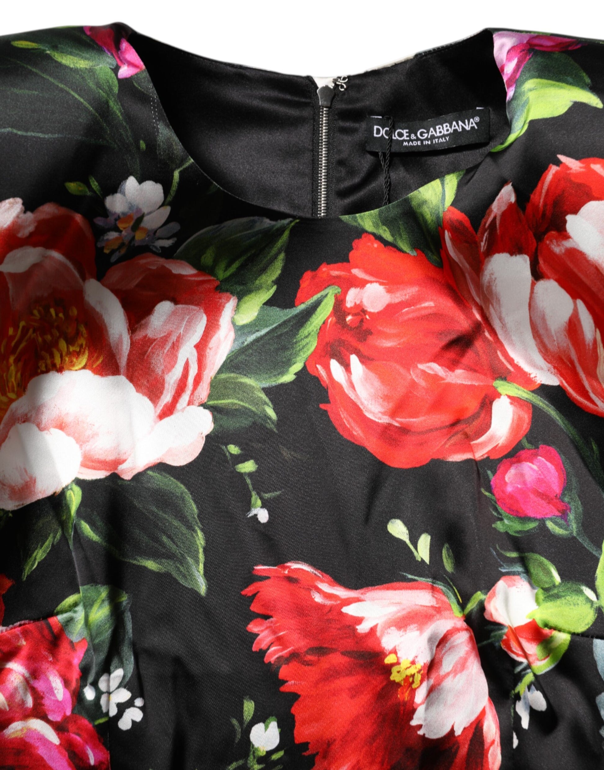 A black dress with a floral pattern featuring red and pink flowers