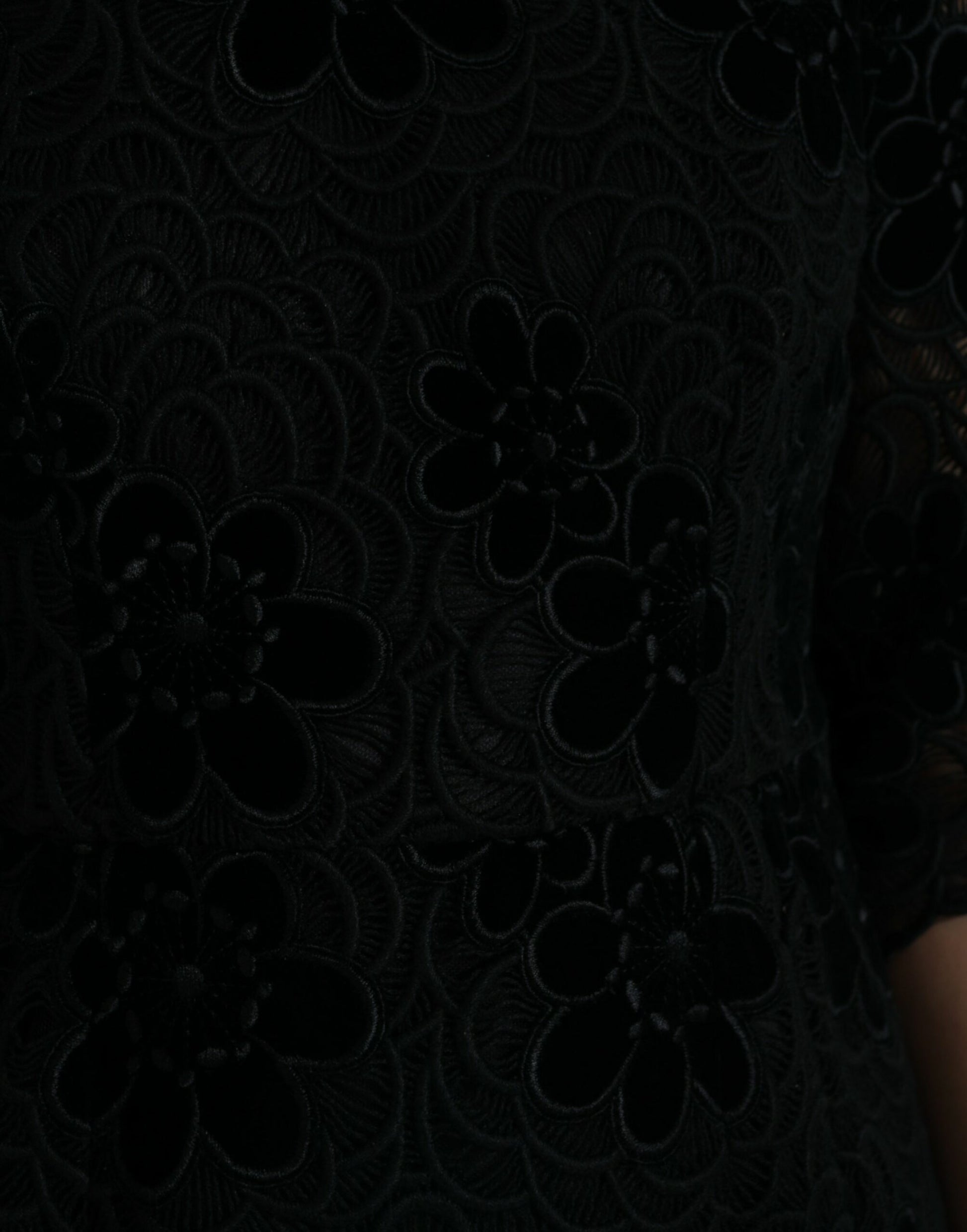 A black lace dress with floral patterns on a woman's torso