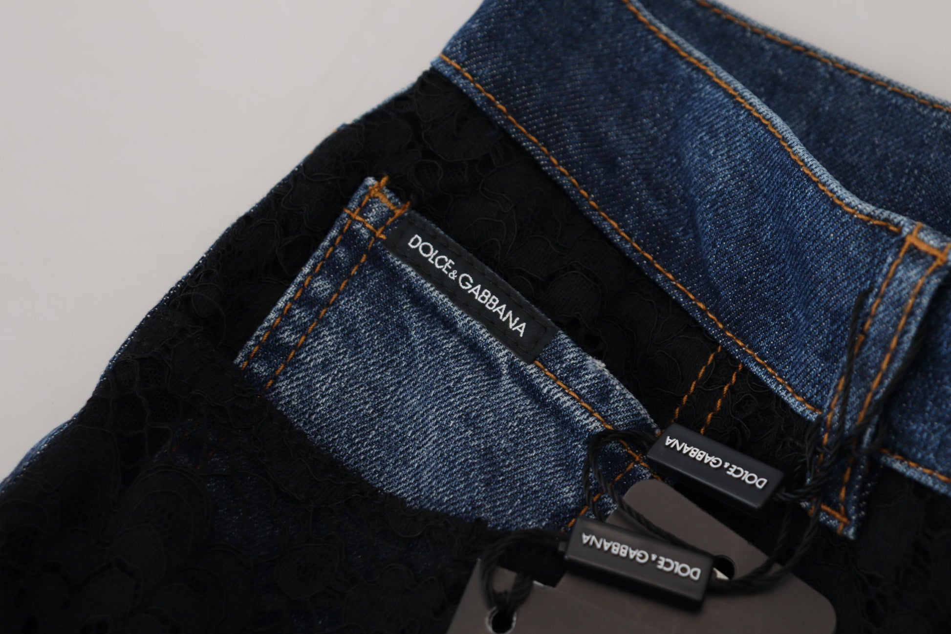 Pair of blue jeans with orange stitching on waistband
