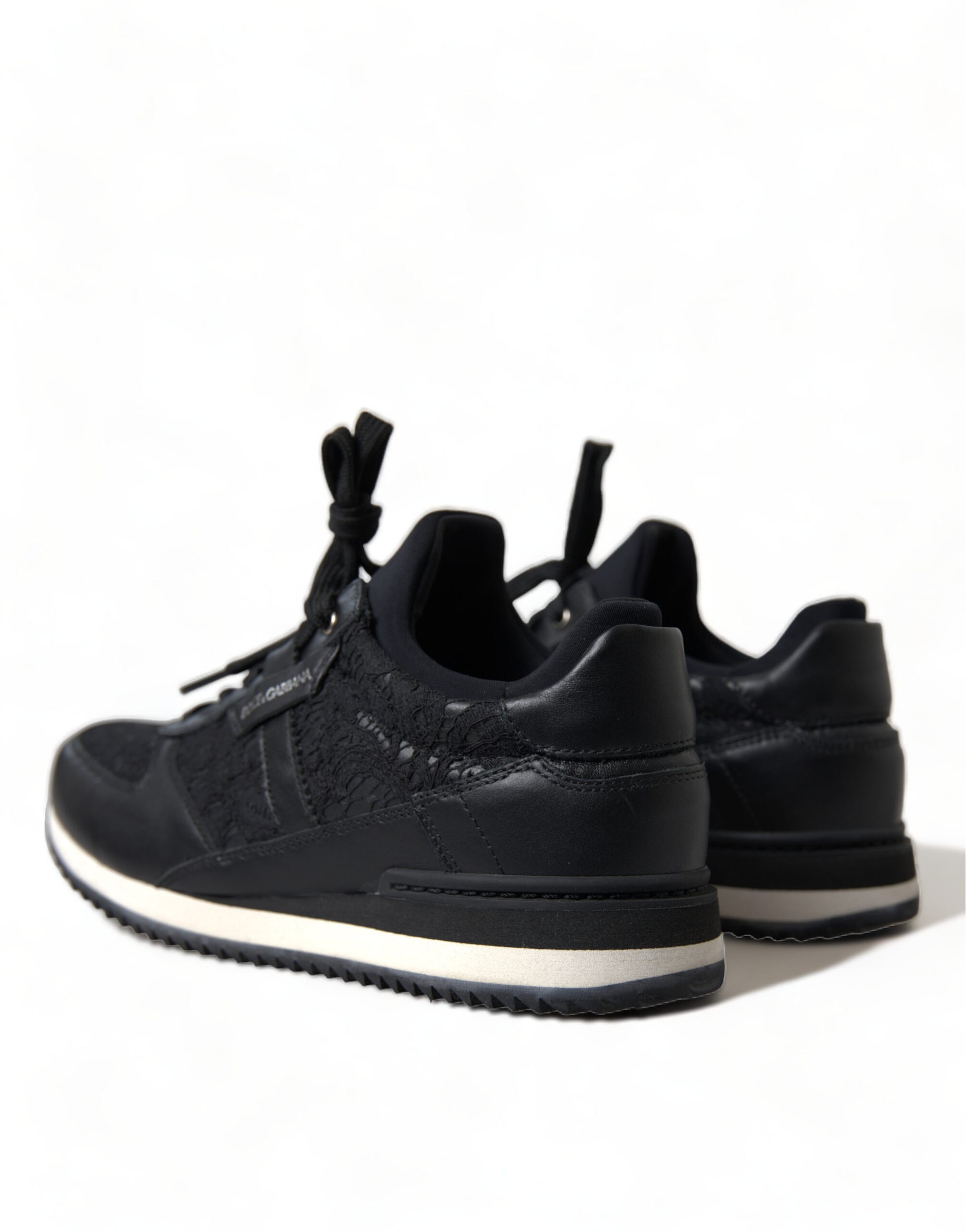 Pair of black sneakers with white sole and laces