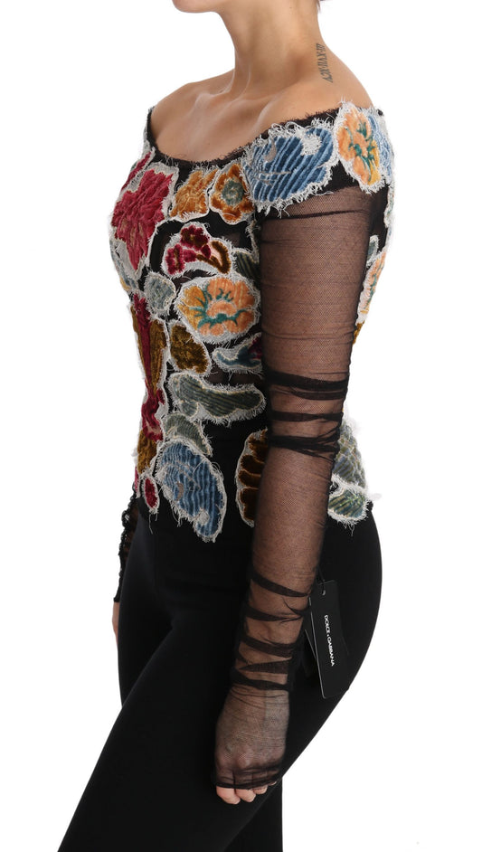 Woman wearing a colorful top with mesh sleeves and black pants