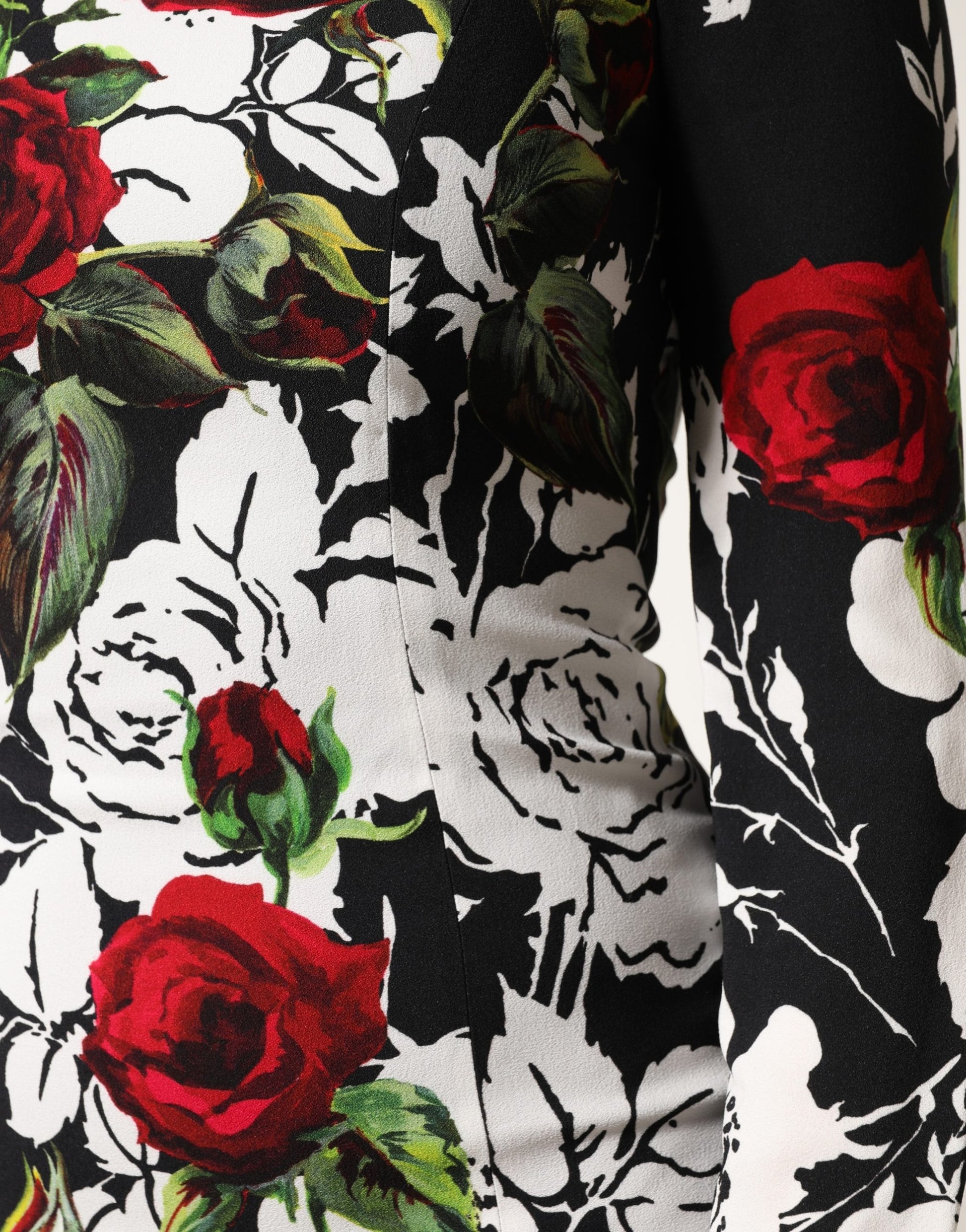 A black dress with a floral pattern featuring red roses and green leaves