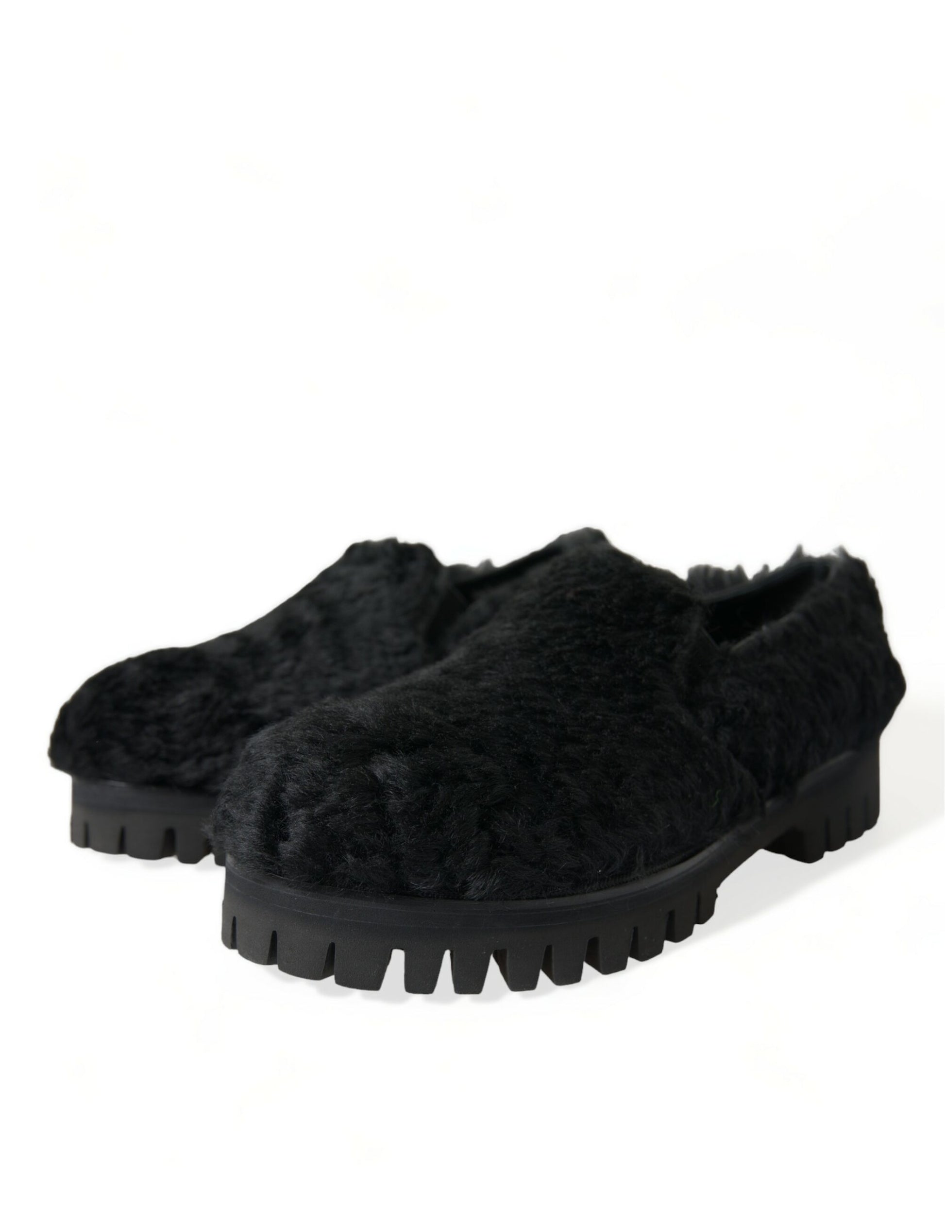 Pair of black furry slippers with a thick sole and a patterned design on top