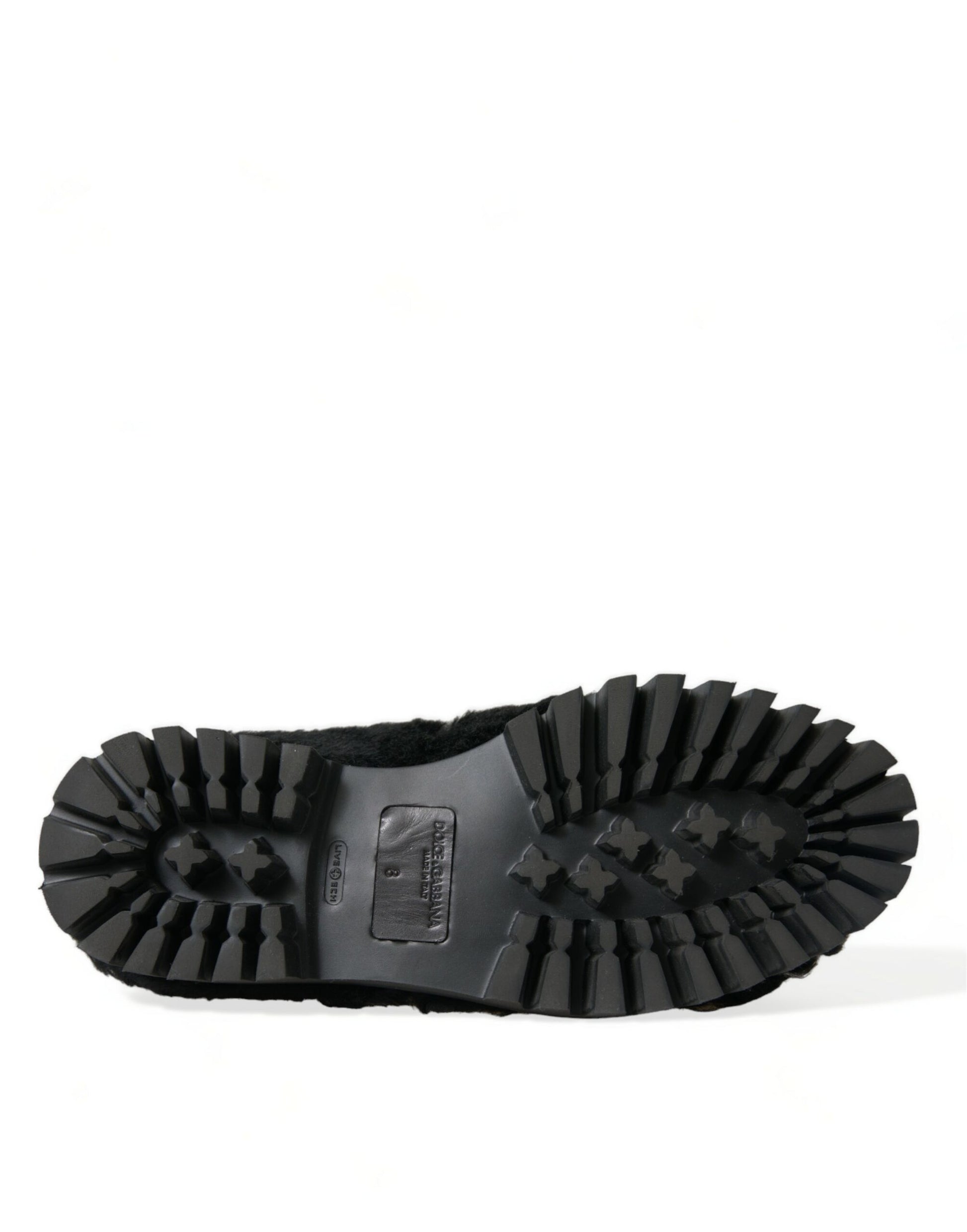 Black rubber boot with deep treads and a small logo on the side