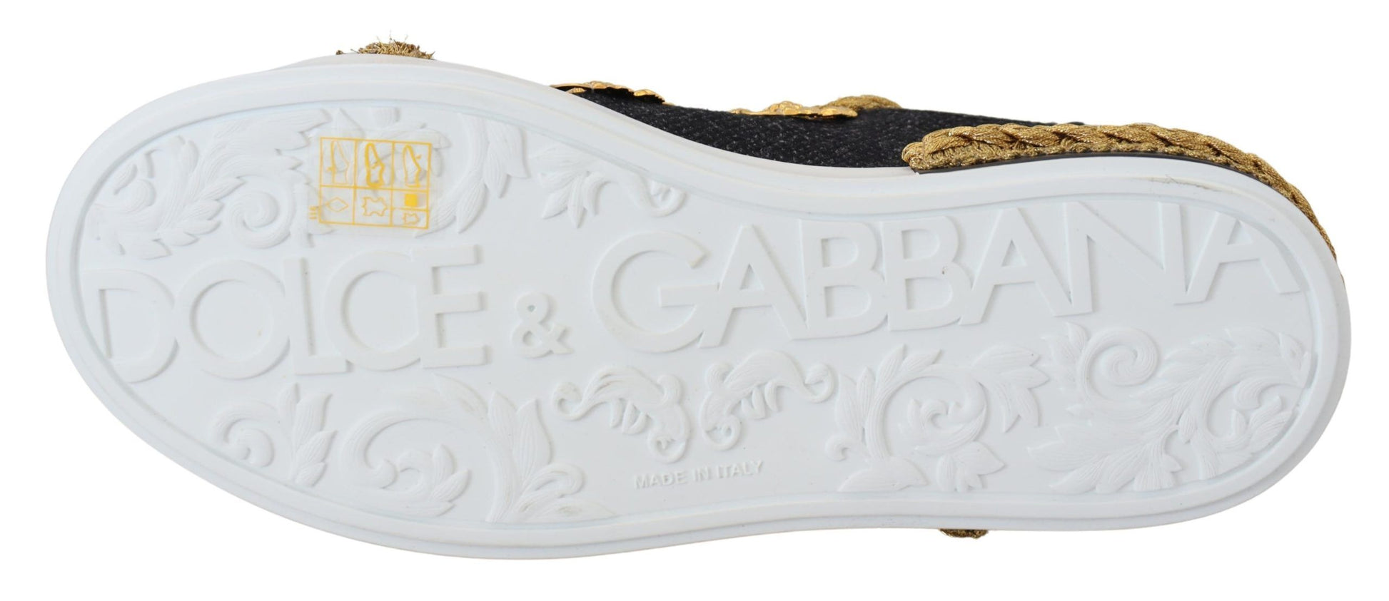 A pair of black and gold leather sneakers with a baroque design
