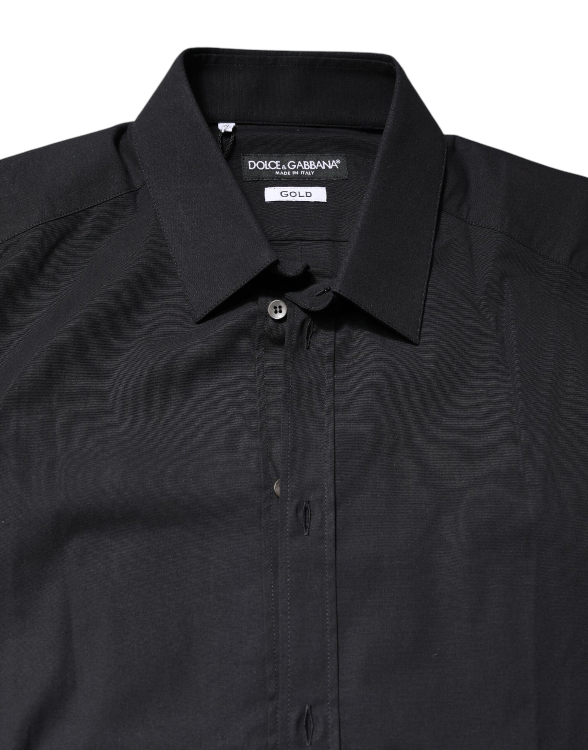 A black dress shirt with gold accents, featuring long sleeves and a collar. It is designed by Dolce & Gabbana