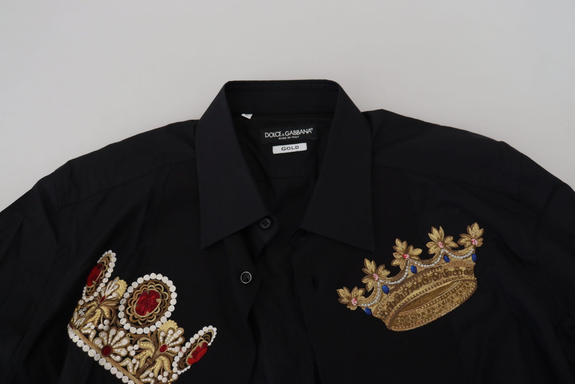 A black dress shirt with gold crown embroidery on the chest