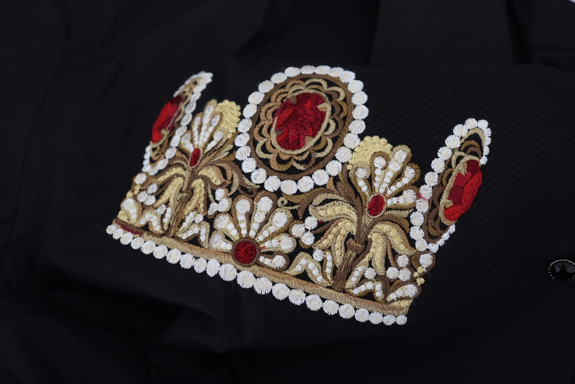 A black dress with a gold crown embroidery on the front