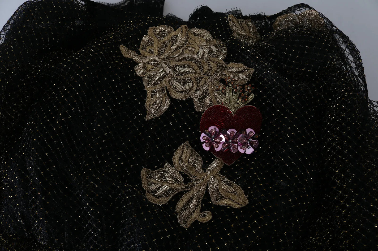 A black dress with gold embroidery and crystals, featuring a heart design