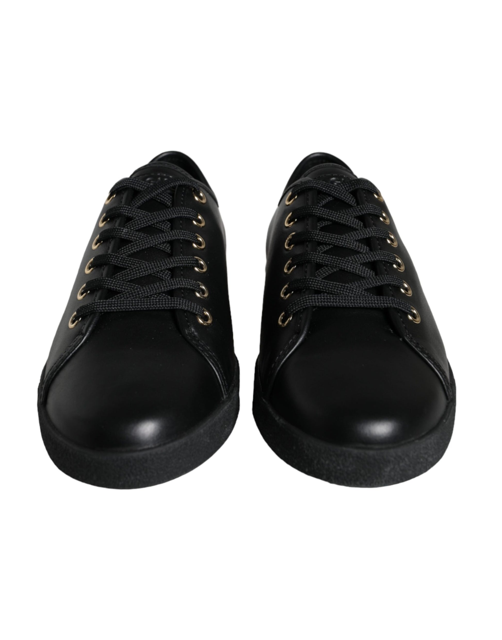 Pair of black shoes with gold laces and eyelets