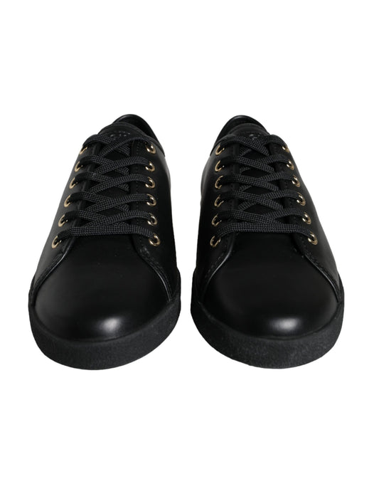 Pair of black shoes with gold laces and eyelets