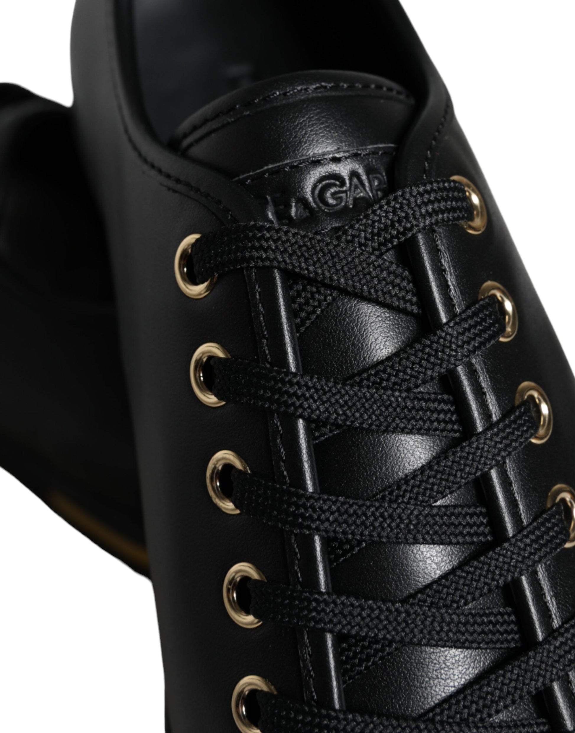 Black leather shoe with gold lace eyelets and a black lace