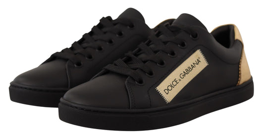Pair of black sneakers with white laces and a gold logo on the side
