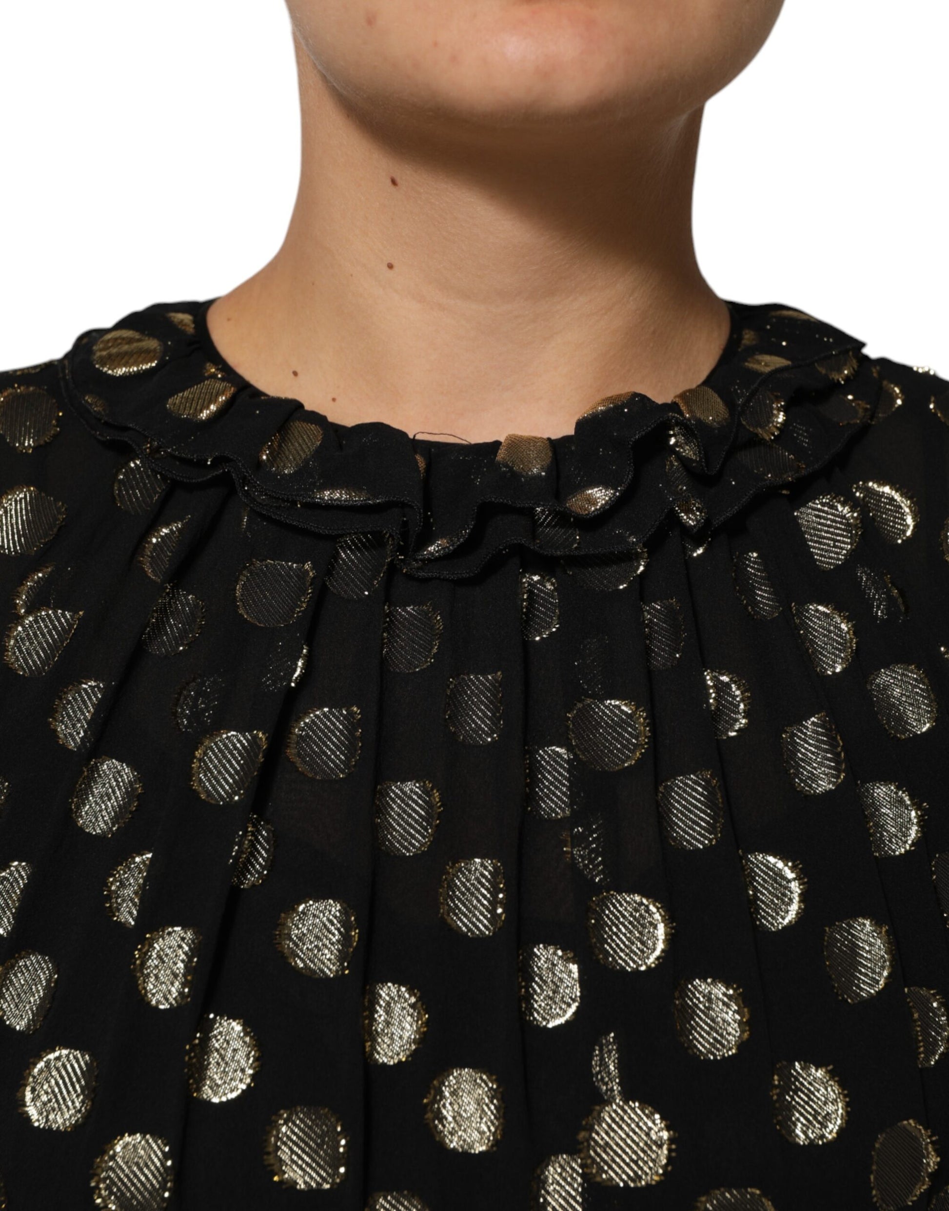 A black dress with gold polka dots and a brocade texture