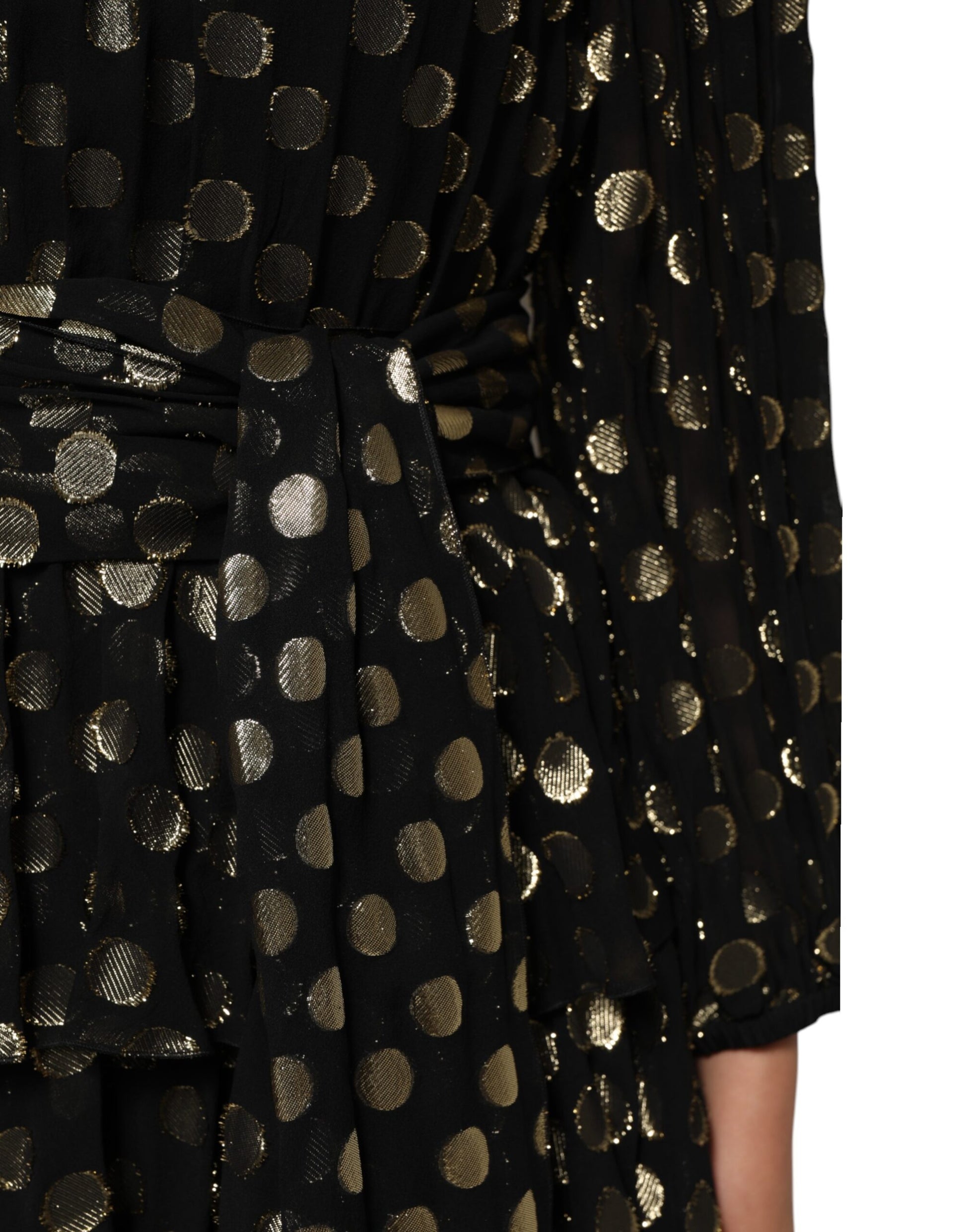 A black dress with gold polka dots and a silky texture, featuring a brocade pattern