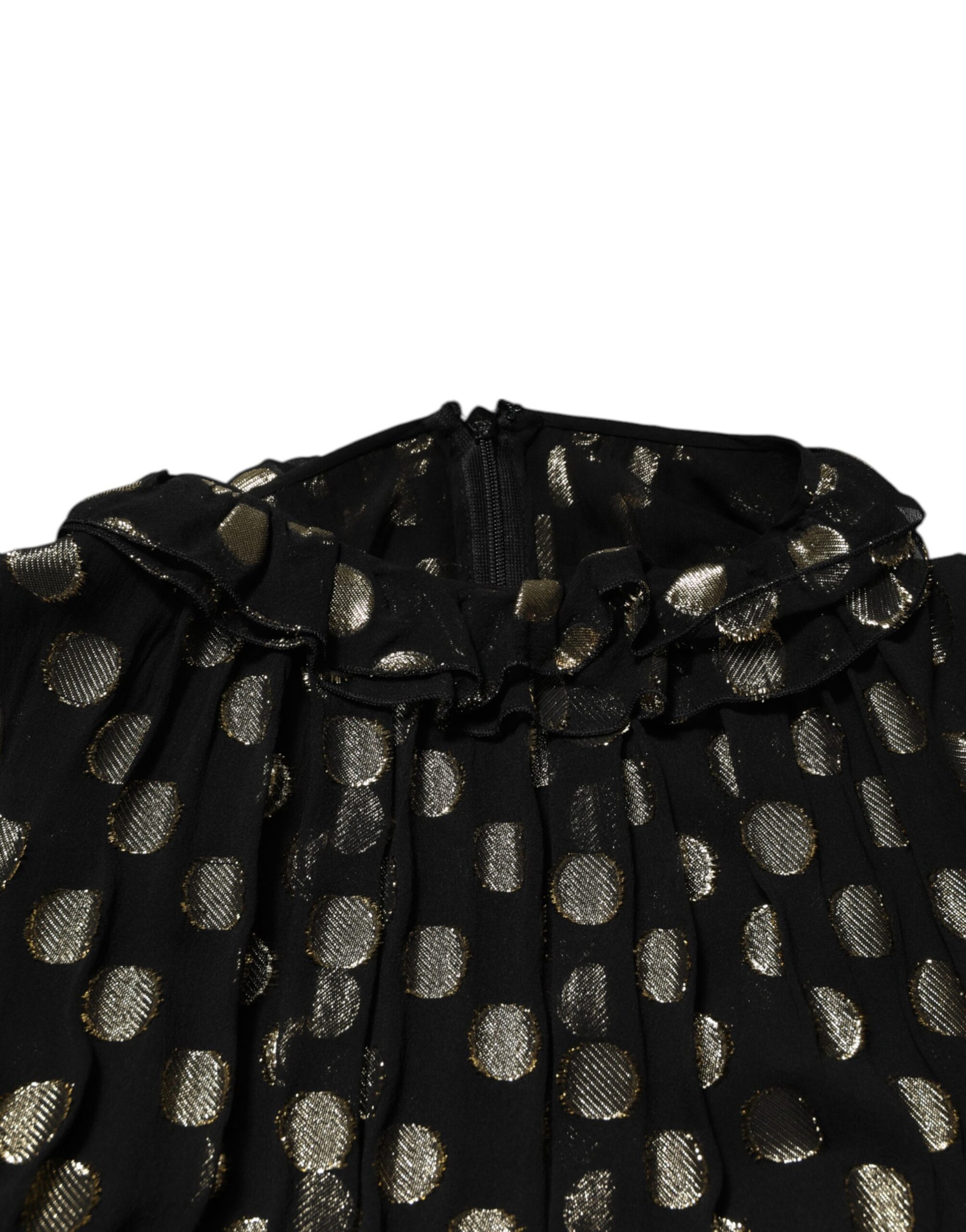 A black dress with gold polka dots and a ruffled hem