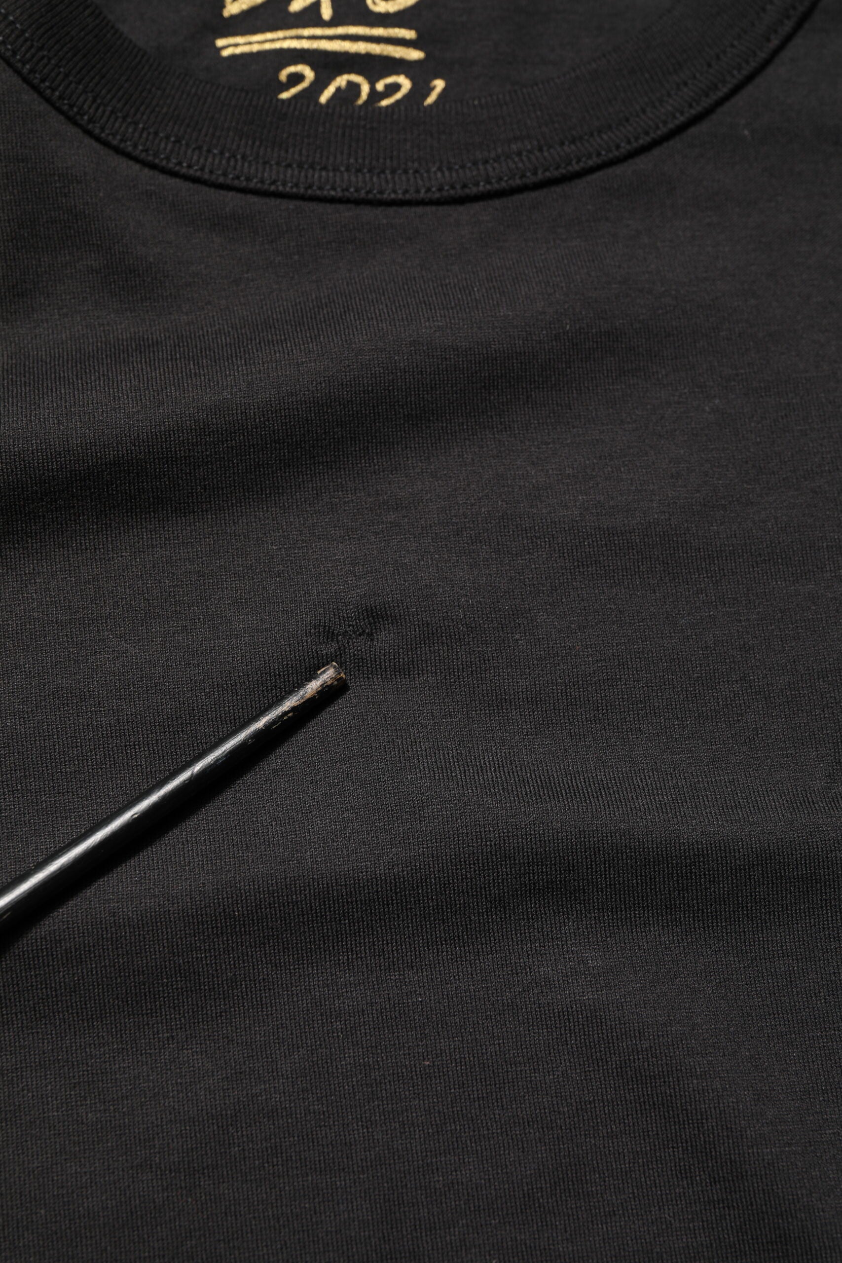 Black t-shirt with gold lettering on front