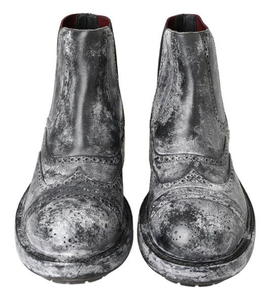Pair of black boots with silver speckles and a red sole