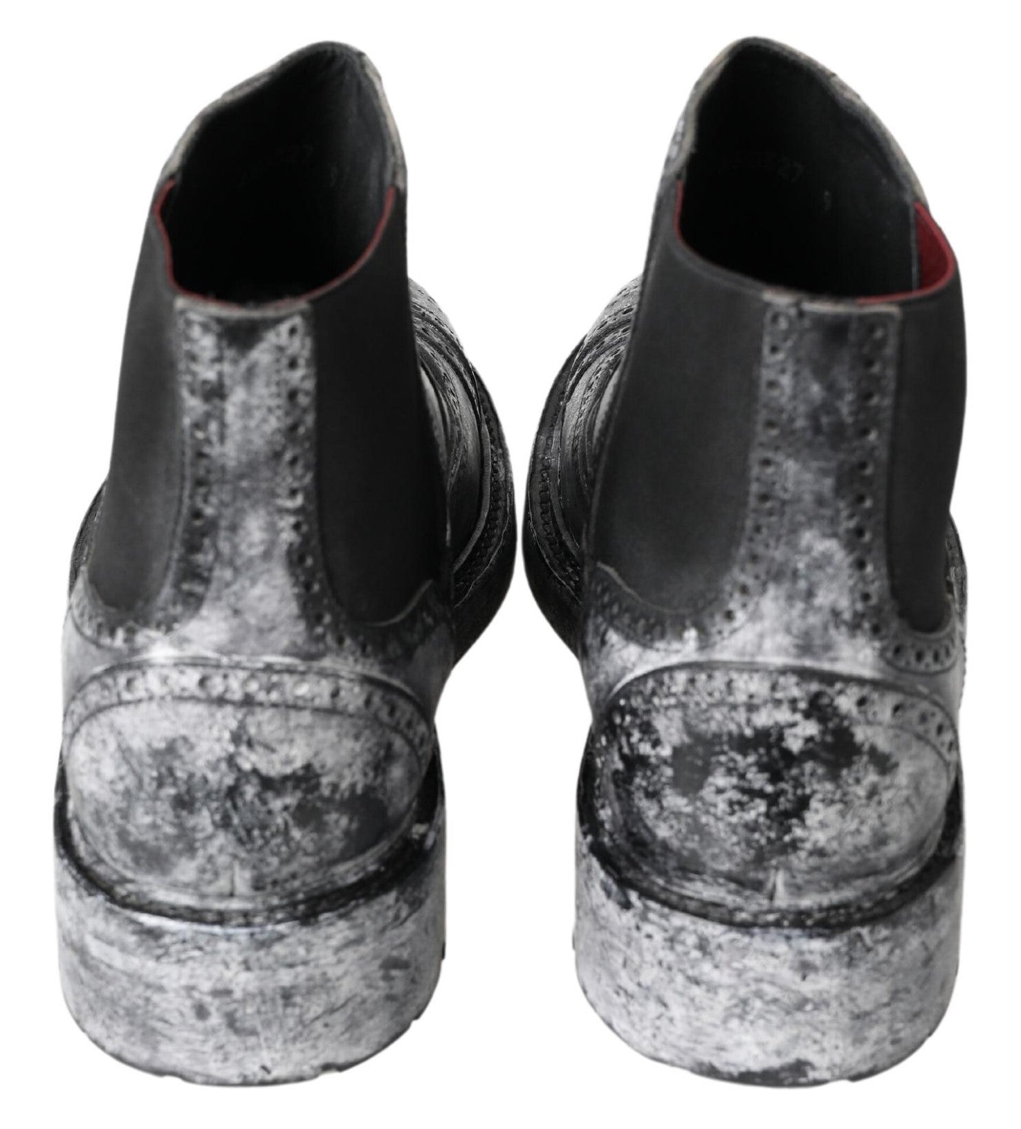 Pair of black shoes with silver speckles and muddy bottoms