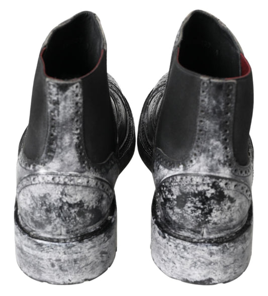 Pair of black shoes with silver speckles and muddy bottoms