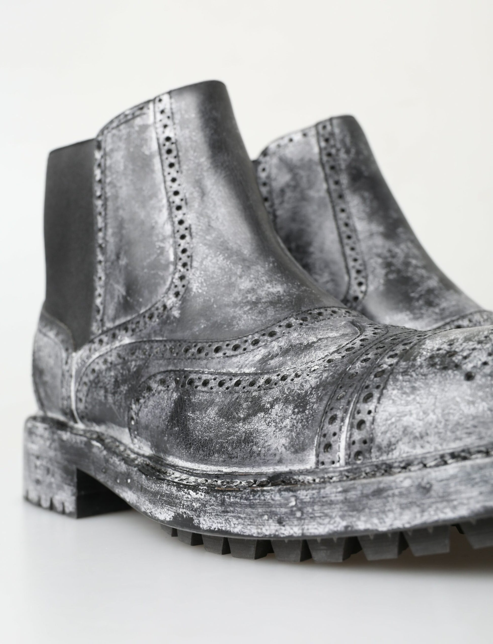 Pair of silver boots with lace detailing and a chunky heel