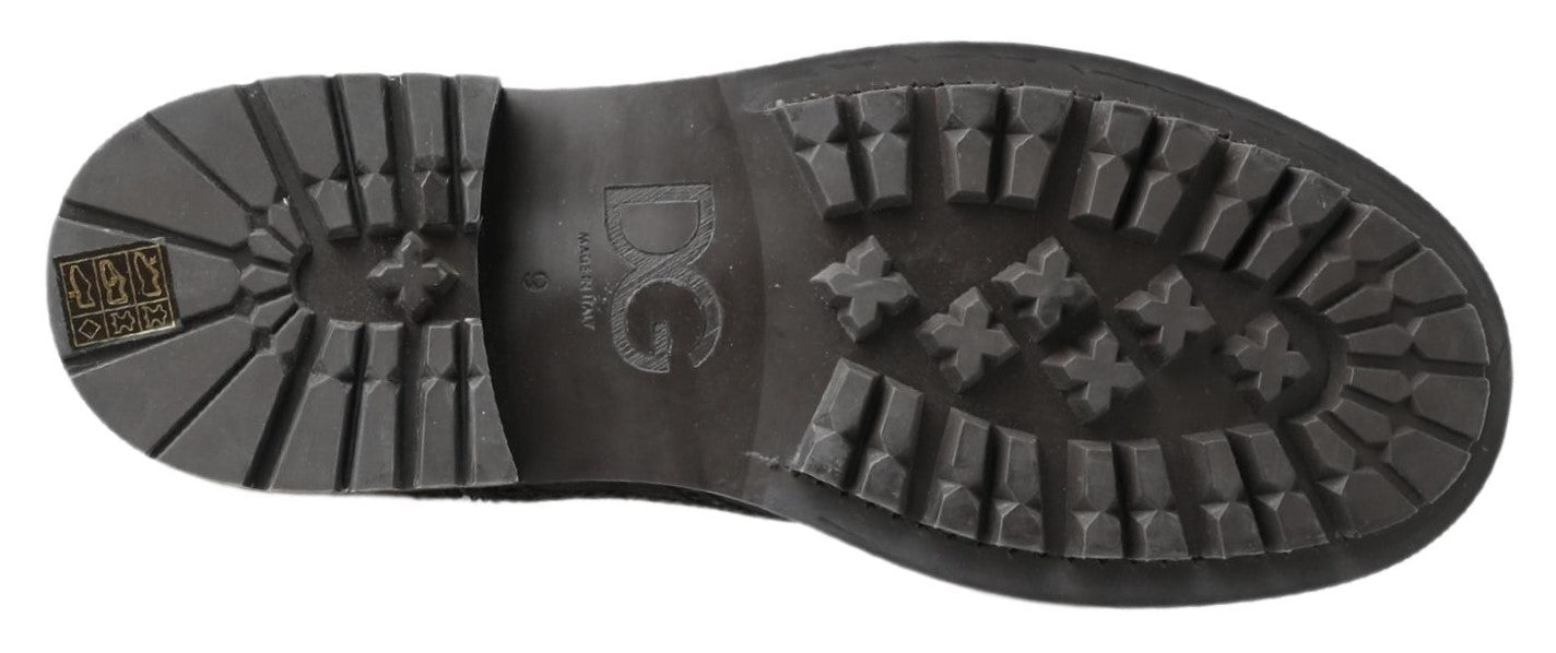 Pair of black boots with treads and a logo on the side