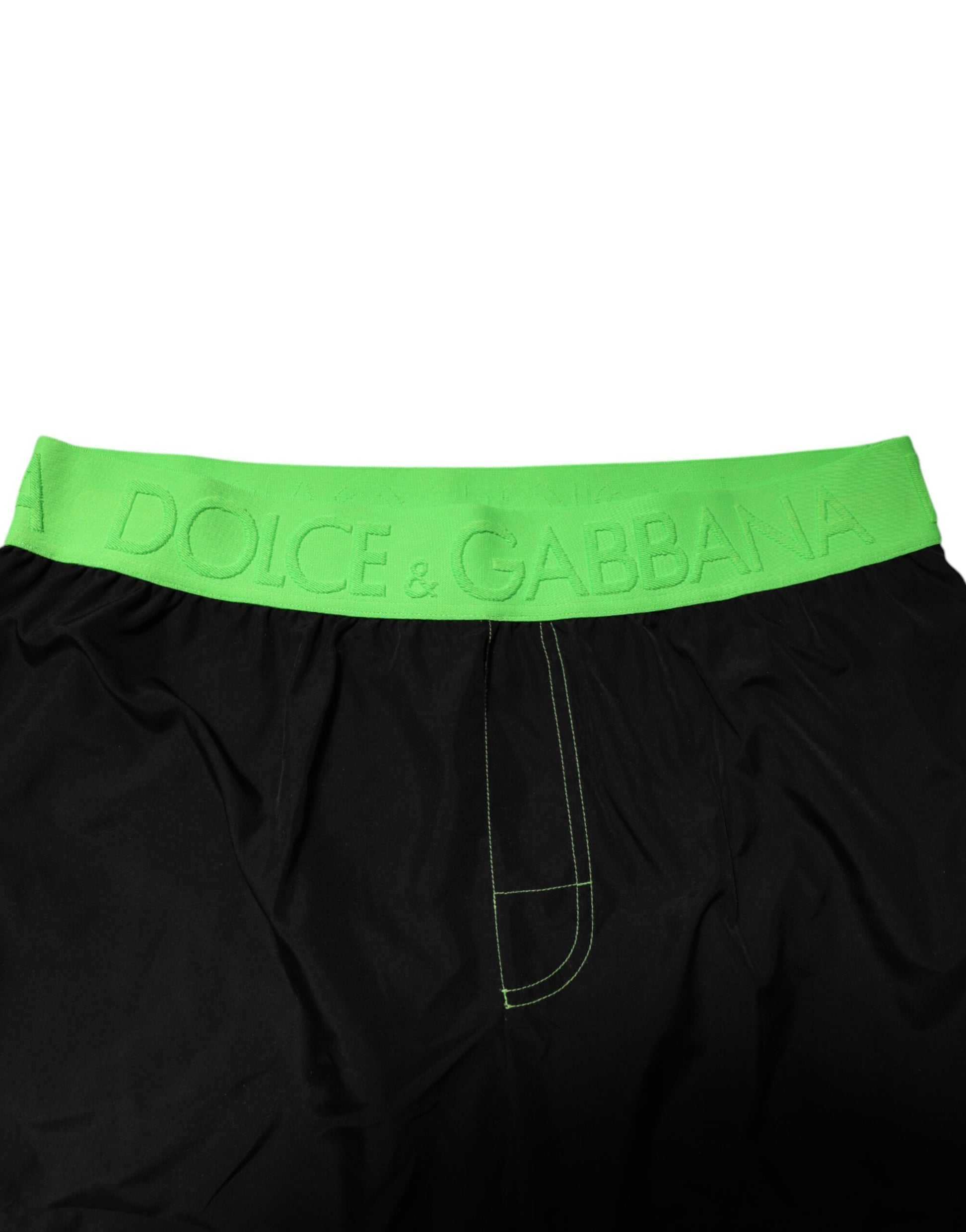 Black boxer shorts with green trim and brand name on waistband