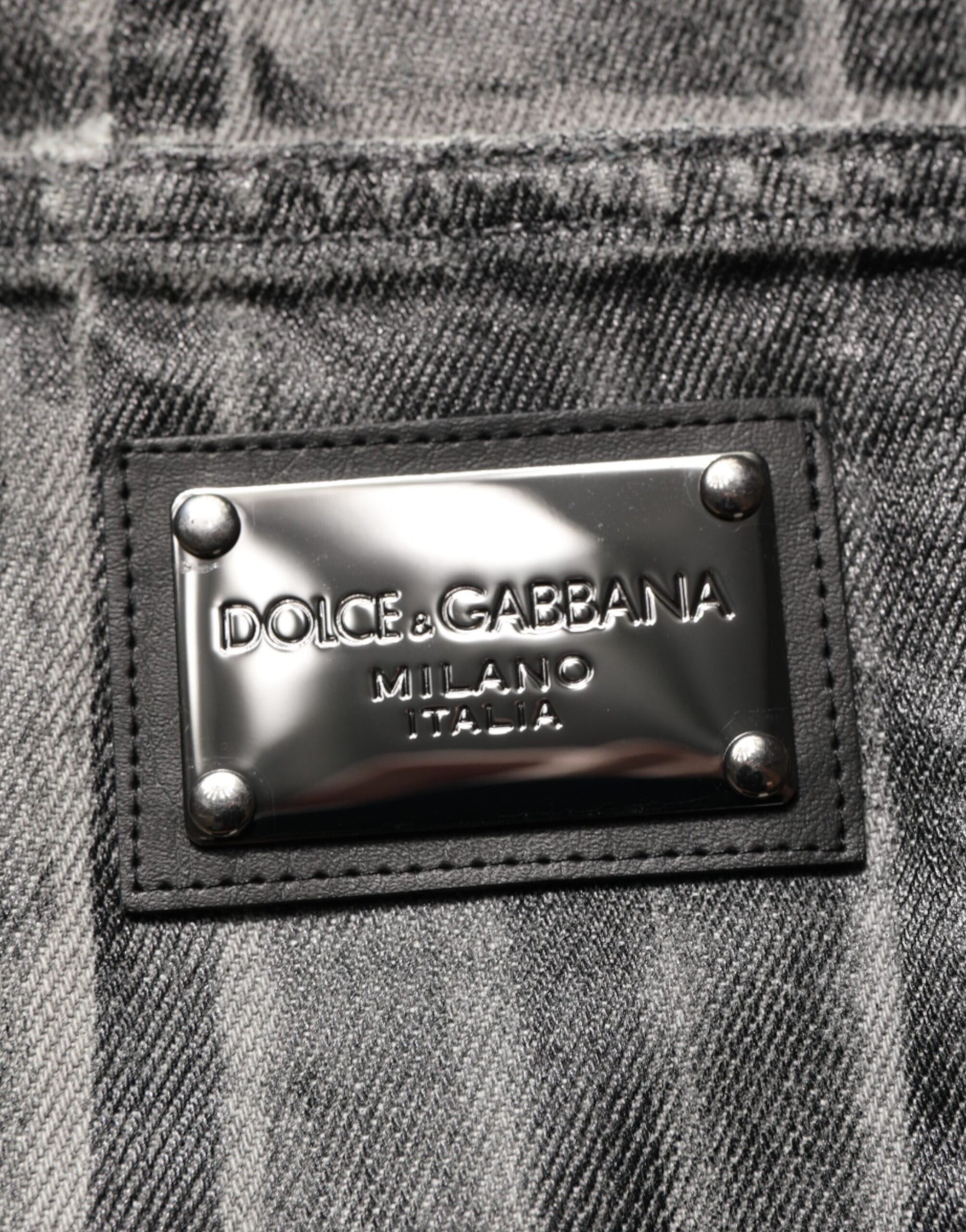 Silver metal brand label on denim fabric