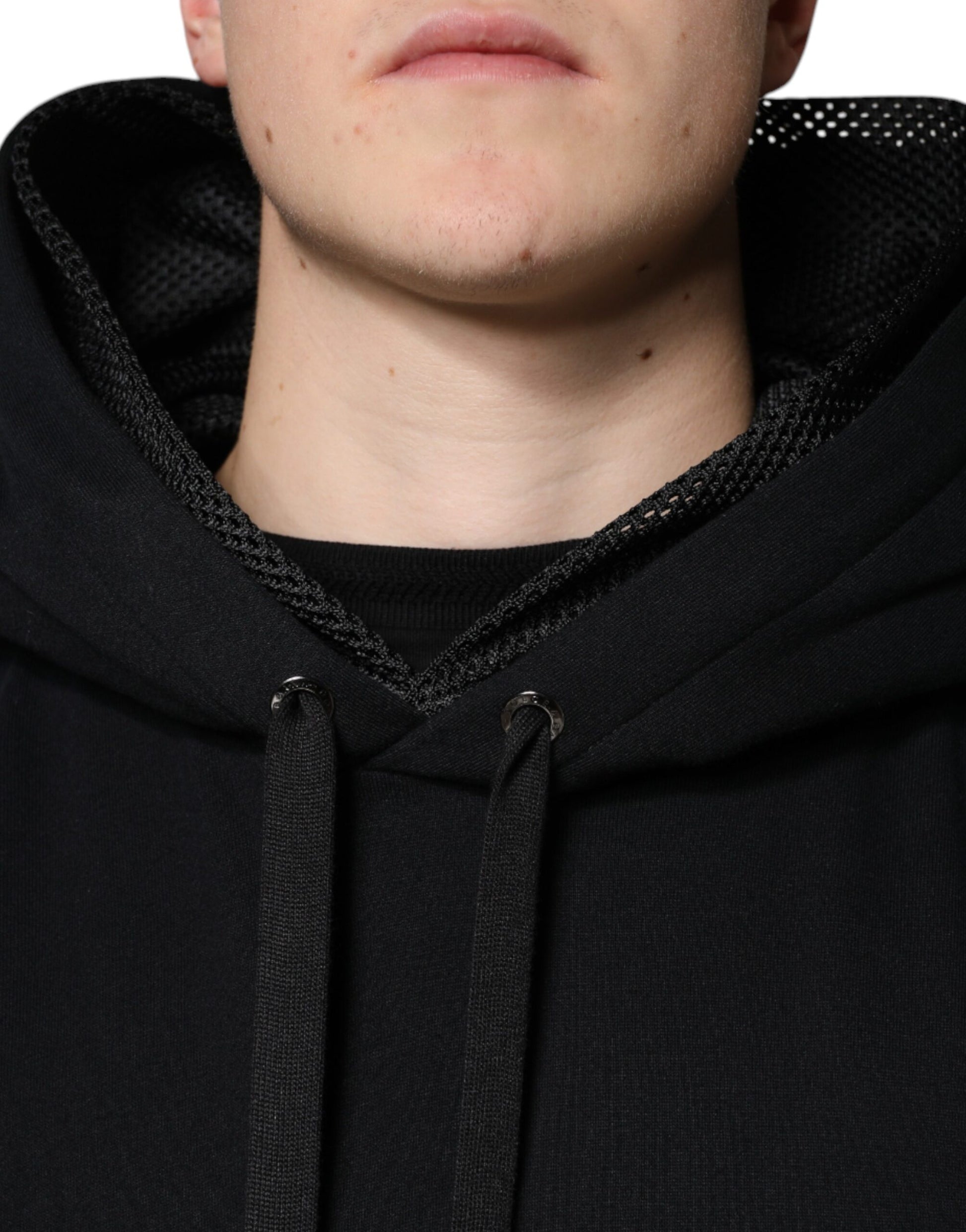 The man is wearing a black hoodie