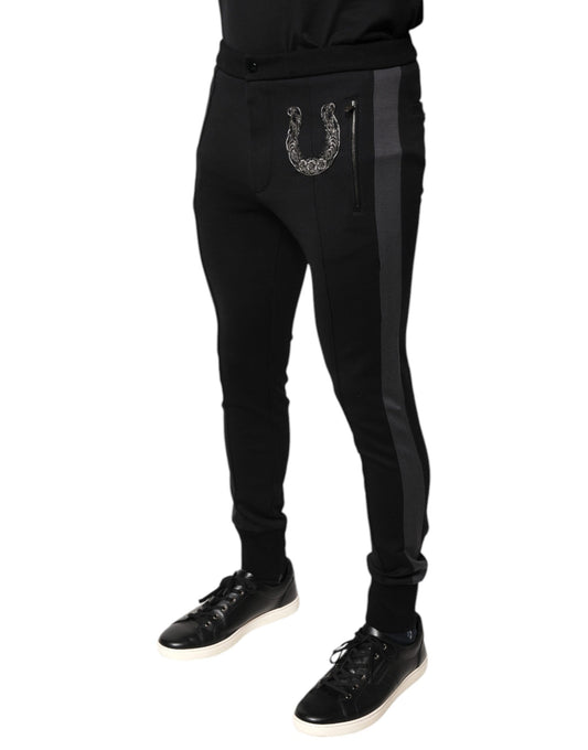 Black track pants with a silver buckle on the side
