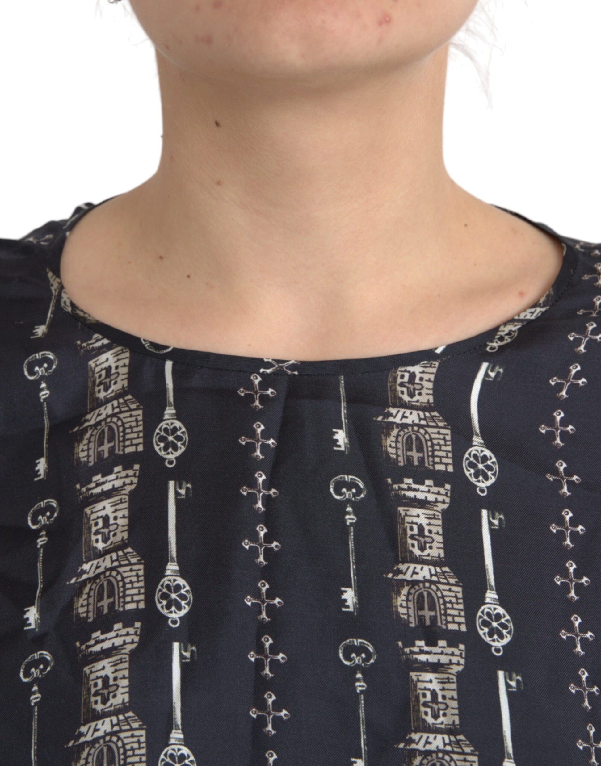Woman wearing a dark blue blouse with embroidered design on neckline