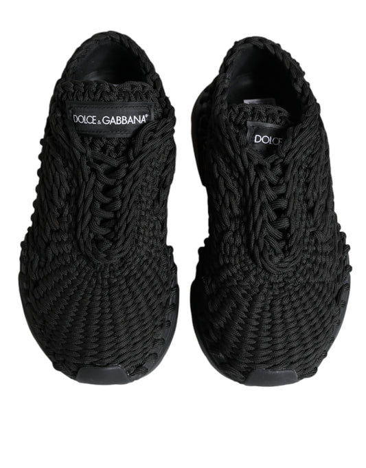 Pair of black sneakers with white branding and laces
